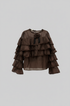 Blusa marrone con balze su sfondo grigio chiaro