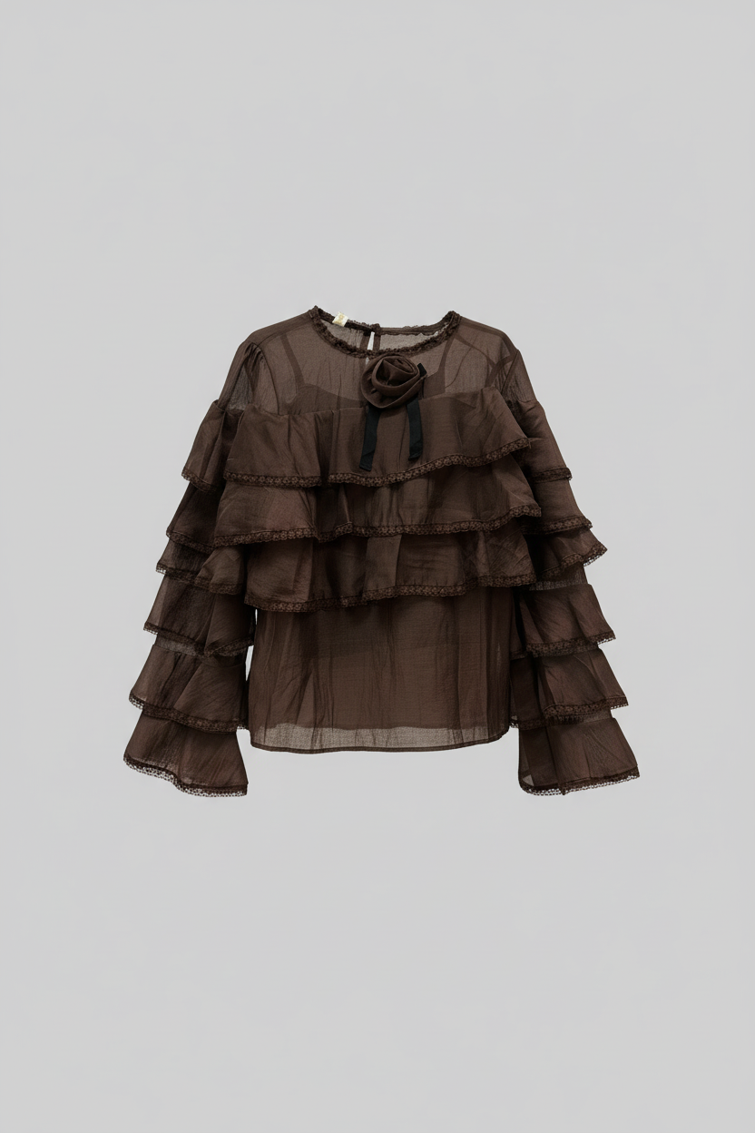 Blusa marrone con balze su sfondo grigio chiaro
